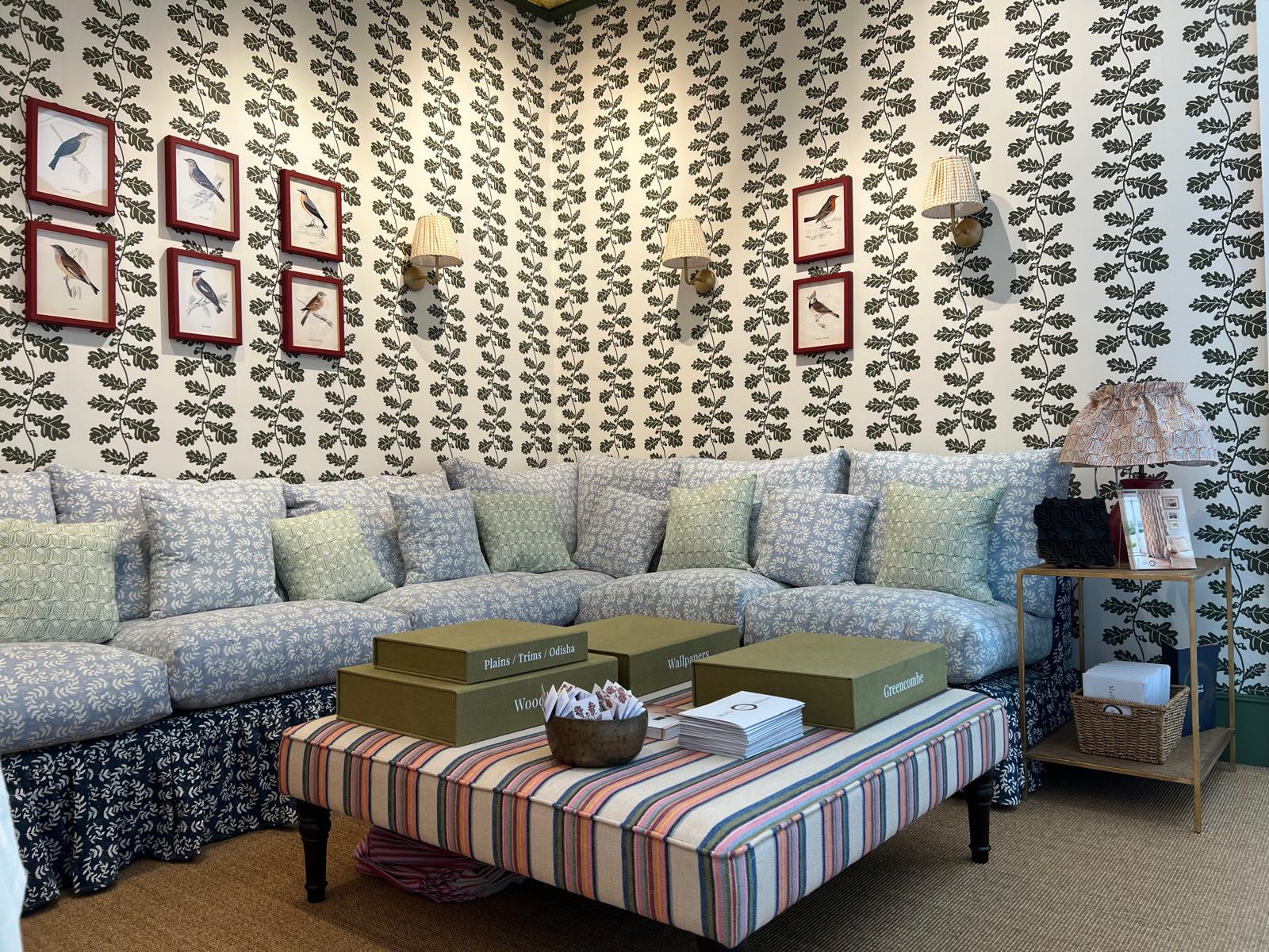 Beautifully styled interior with patterned wallpaper, bird prints and a floral sofa
