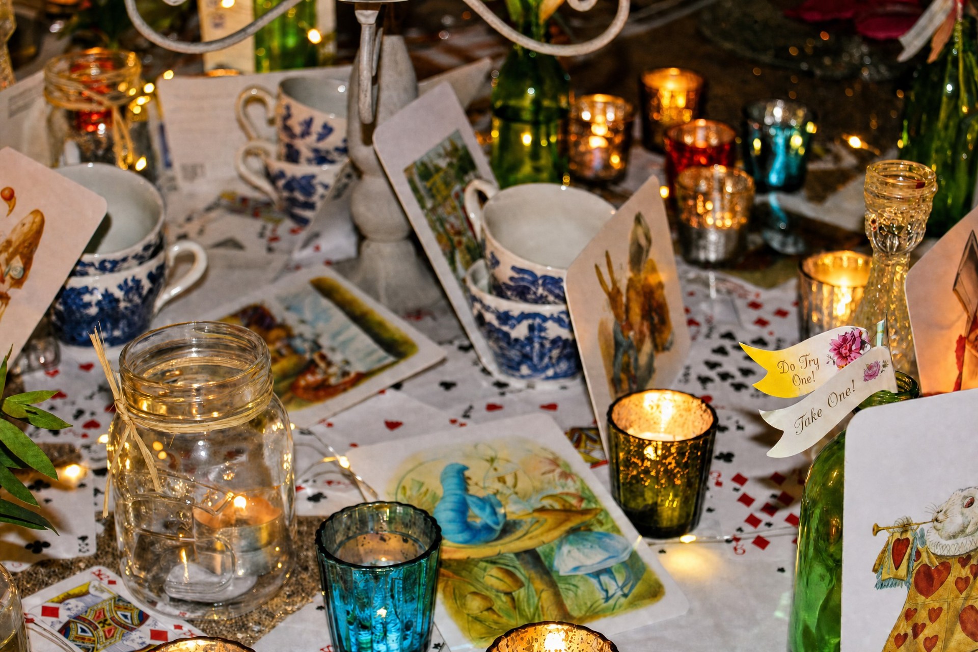 Alice in Wonderland themed tablescape with candles, teacups and playing cards