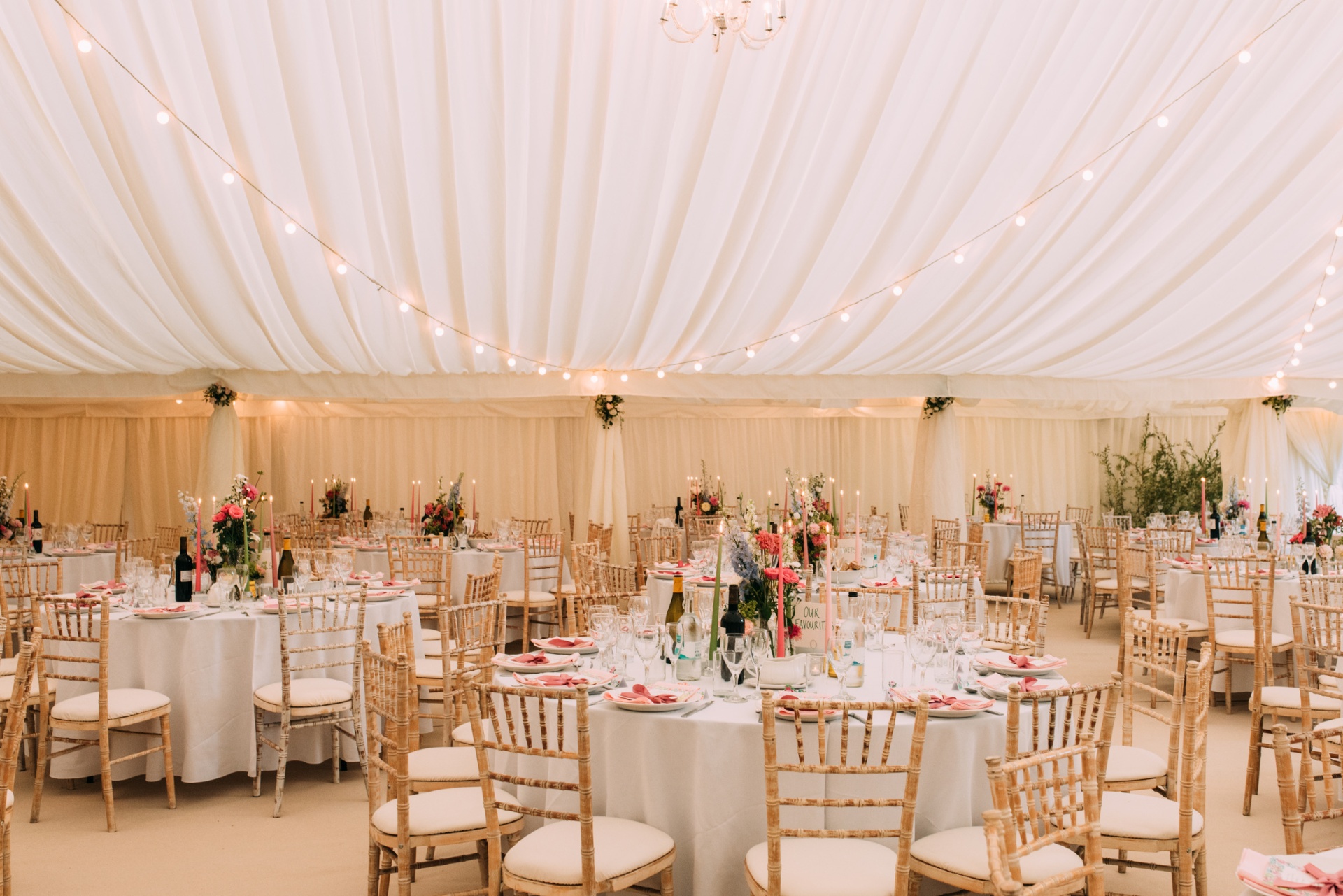 Elegant marquee wedding reception with beautifully dressed tables and floral arrangements